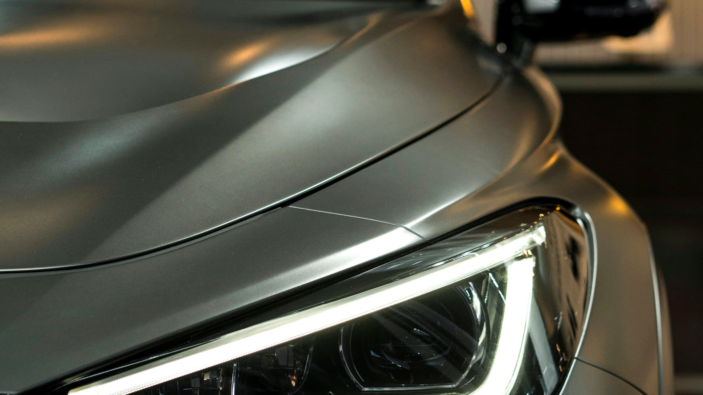 Carro oscuro recién detallado de noche, con la luz recorriendo la pintura